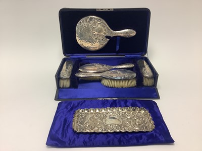 Lot 390 - Edwardian silver five piece dressing table set with embossed foliate scroll decoration, in fitted case (Chester 1906)