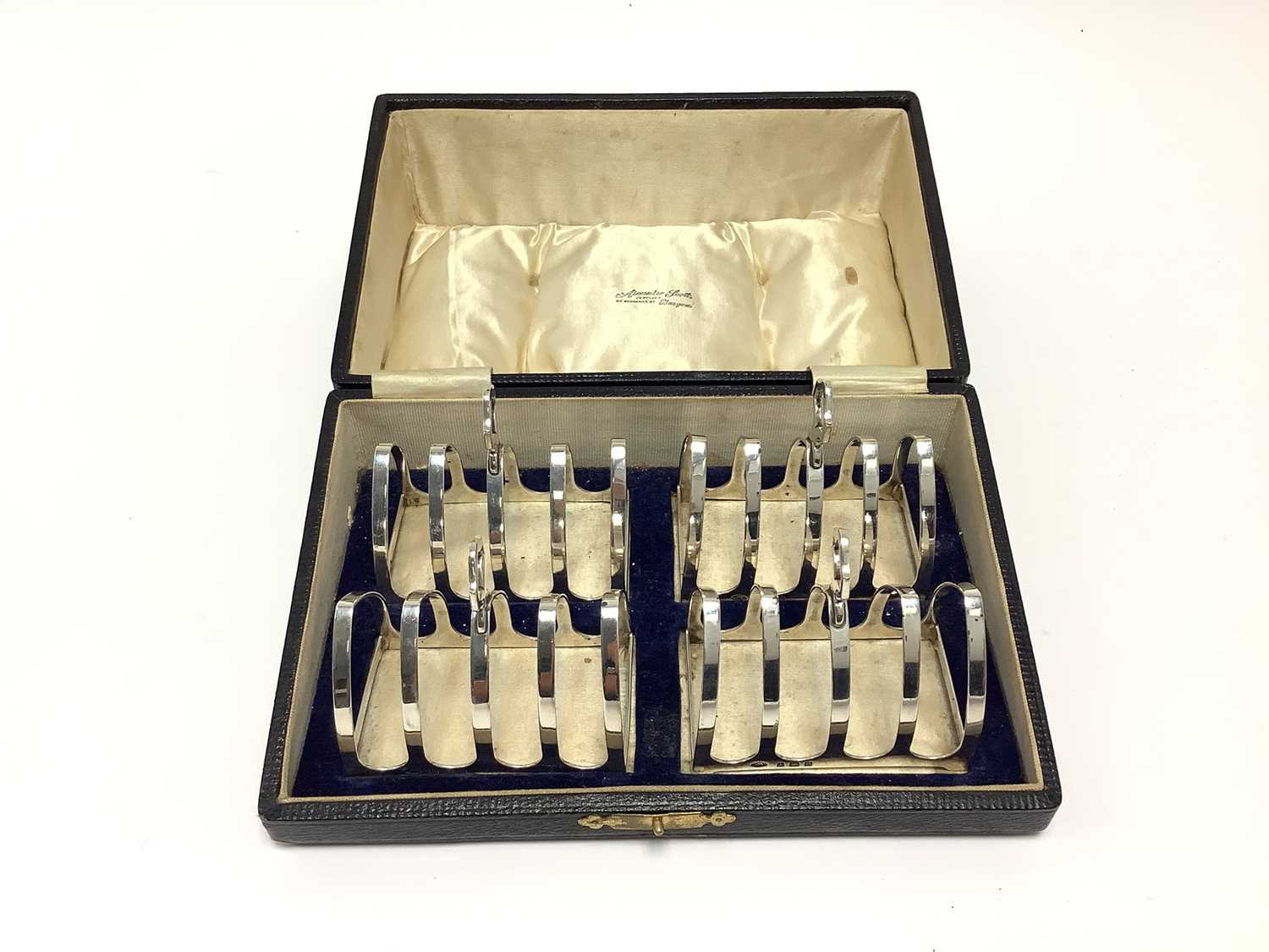Lot 212 - Set of four silver toast racks in fitted