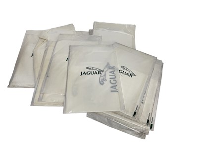 Lot 72 - Sixteen 1980's / 90's Jaguar branded dealership packs containing paper floor mat, seat cover and napkin all with Jaguar branding.