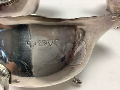 Lot 224 - Pair 1920s silver sauce boats of conventional form with open scroll handles on pad feet (Chester 1927) marks rubbed , together with one other sauce boat (Birmingham 1957) Adie Bros. Ltd. All at...