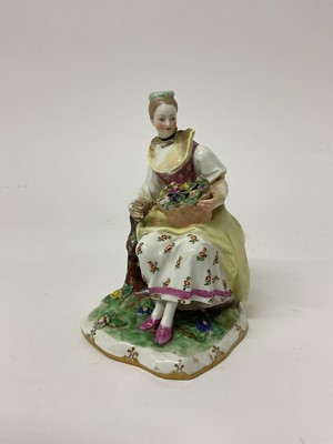 Lot 64 - Vienna figure of a young woman, seated, holding a basket, circa 1770