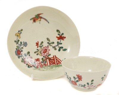 Lot 94 - Rare Worcester tea bowl and saucer, painted in Chinese style with a bird in flight, above an iron red fence and flowering trees, circa 1754-55. NB. A coffee cup and saucer in this...