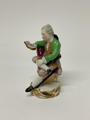 Lot 122 - Continental porcelain figure of a seated man reading a book