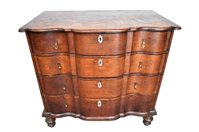 Lot 1212 - 18th century Continental oak chest of shaped outline, with four long drawers