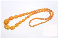 Lot 806 - Amber bead necklace with a string of oval...