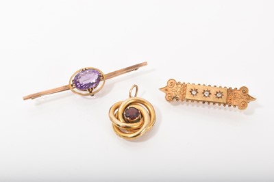 Lot 476 - Victorian Etruscan Revival 15ct gold and diamond bar brooch, Victorian yellow metal and garnet knot pendant and an Edwardian 9ct gold and amethyst bar brooch (3)