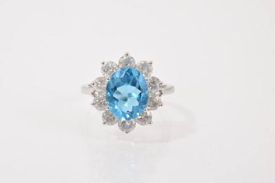 Lot 51 - Blue topaz and diamond cluster ring with an oval mixed cut blue topaz surrounded by ten brilliant cut diamonds