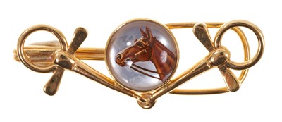 Lot 403 - Vintage yellow metal and Essex crystal tie clip with a central Essex crystal disc depicting a race horse in a yellow metal mount in the form of a horse bit, 50mm