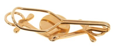 Lot 403 - Vintage yellow metal and Essex crystal tie clip with a central Essex crystal disc depicting a race horse in a yellow metal mount in the form of a horse bit, 50mm