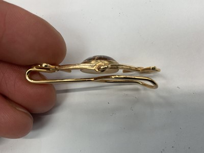 Lot 403 - Vintage yellow metal and Essex crystal tie clip with a central Essex crystal disc depicting a race horse in a yellow metal mount in the form of a horse bit, 50mm