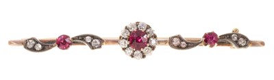 Lot 415 - Victorian ruby and diamond brooch, the central flower head cluster with a mixed cut ruby measuring approximately 4.6mm diameter, surrounded by nine old cut diamonds on a gold knife edge bar with...