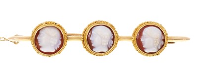 Lot 416 - Victorian cameo brooch with three carved hard stone cameos in gold mounts on a gold bar brooch, 50mm