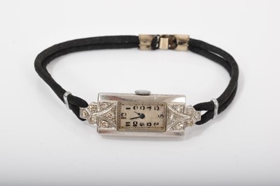 Lot 590 - Art Deco diamond and platinum ladies cocktail watch in a tank shape platinum case with diamond set lugs on a black twin cord bracelet