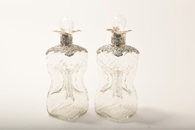 Lot 385 - Pair of Edwardian silver mounted decanters, with pinched wrythen glass bodies, (London 1901 & 1904), 20.5cm and 21cm high