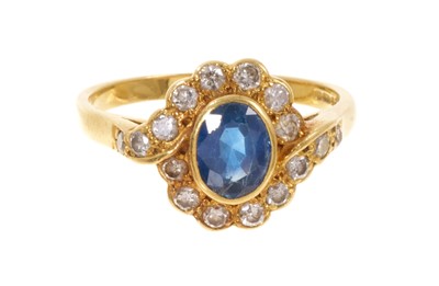 Lot 430 - Sapphire and diamond cluster ring with a central oval mixed cut sapphire surrounded by sixteen brilliant cut diamonds in a cross over setting on 18ct gold shank. Ring size Q