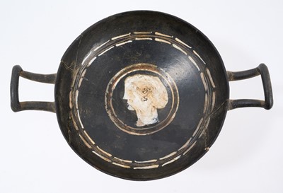 Lot 882 - Ancient Greek attic pottery kylix, centred by a relief mask, 21cm wide