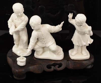 Lot 31 - Chinese blanc de chine group of children playing, in the Cultural Revolution style, on wooden base measuring 21cm across