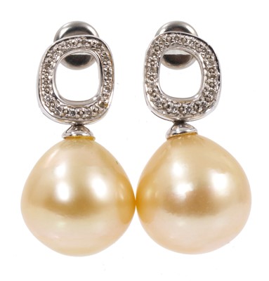 Lot 497 - Pair of cultured pearl and diamond earrings, each with a large cultured pearl of pale gold/champagne tone, measuring approximately 12.5mm-13mm suspended from a diamond set loop in white gold set...