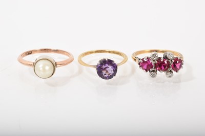 Lot 531 - Three gold gem set dress rings to include 18ct gold cultured pearl single stone ring in millegrain setting, 18ct gold amethyst single stone ring in platinum claw setting and a synthetic ruby thr...