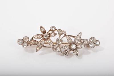 Lot 570 - Victorian diamond floral spray brooch with trailing flowers and scrolls set with old cut diamonds in silver and gold setting, estimated total diamond weight approximately 0.70cts, length 45mm.