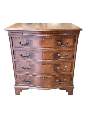 Lot 1312 - 1950s walnut serpentine chest of four long drawers on bracket feet