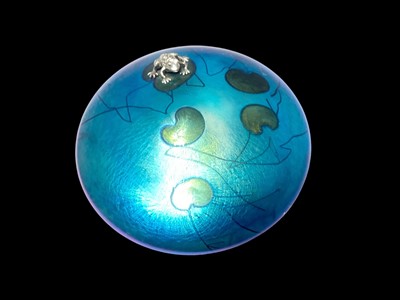 Lot 1157 - John Ditchfield glasform iridescent lily pad paperweight surmounted by frog, signs and labelled to base