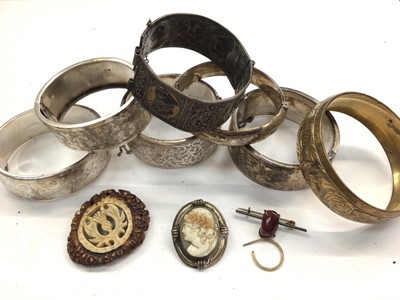 Lot 1117 - Five silver bangles all with engraved decoration, two other bangles, cameo brooch etc