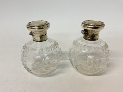 Lot 93 - Pair of antique silver mounted glass scent bottles, of globular form with floral decoration (London 1911)