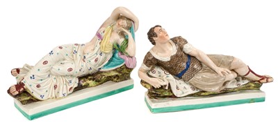 Lot 205 - A pair of early 19th century pearlware glazed figures of Antony and Cleopatra, shown reclining on rectangular bases, polychrome decorated, each 30cm wide