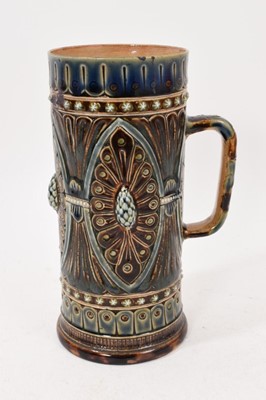 Lot 214 - Doulton Lambeth tall cylindrical tankard by Frank Butler, decorated in relief with a foliate pattern, marks to base, 18cm high