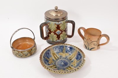 Lot 216 - Group of Doulton Lambeth, including a silver-mounted tyg with scrolling foliate pattern, 19.5cm high, together with a dish by Frank Butler, a basket and a loving cup (4)