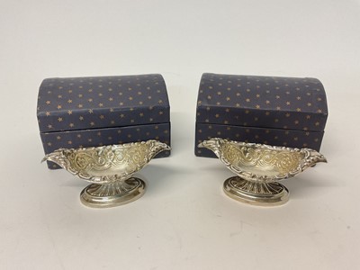 Lot 26 - Pair of silver boat shaped salts with embossed decoration, in domed cardboard trunk-type boxes