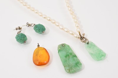 Lot 77 - Cultured pearl necklace with a Chinese carved jade/ green hardstone pendant, one other similar pendant, an amber pendant and a pair of simulated jade earrings