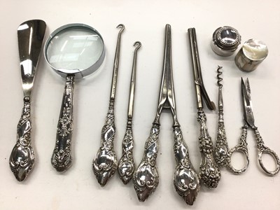 Lot 1088 - Group of silver handled items including a magnifying glass, button hooks, glove stretchers, scissors and two pill pots