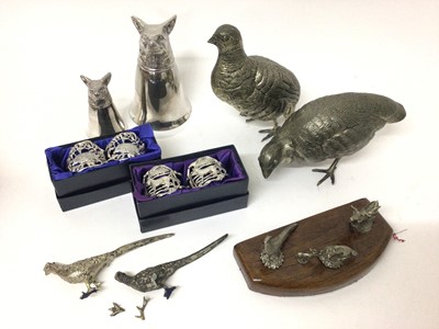 Lot 338 - Two silver plated stirrup cups with fox mask mounts, pair of partridges, pair of miniature pheasants, two pairs of plated napkin rings and a wooden plaque mounted with plated game