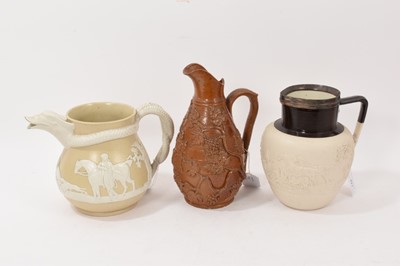 Lot 271 - Three 19th century relief moulded pottery vases, including with with a serpent-form handle and spout, the largest 22.5cm high