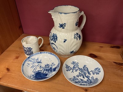 Lot 217 - Four pieces of 18th century English porcelain to include a Lowestoft saucer, a Worcester saucer, a Worcester cabbage leaf jug and a Liverpool coffee can (4)