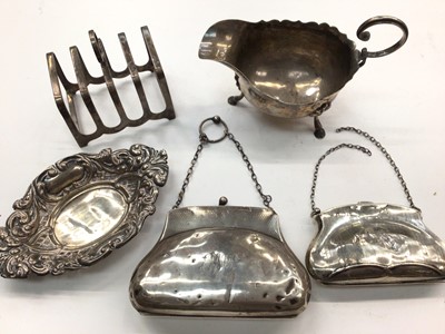 Lot 1102 - Two silver coin purses, silver toast rack, pierced silver bon bon dish and a silver sauce boat (5)