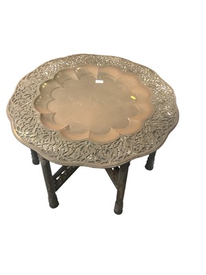 Lot 1497 - Eastern brass topped occasional table on folding base, 77cm diameter