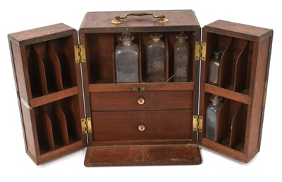 Lot 1093 - George III mahogany apothecary cabinet, with surmounting brass drop handle and enclosed by pair of swing doors, the interior fitted with various glass jars and other accessories, 27cm high