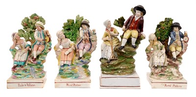 Lot 291 - Four early 19th century pearlware groups of couples resting on rockwork by a tree, one inscribed 'Rural Pastime', another charmingly misspelled 'Rule & Pastime', the largest 22cm high (3)