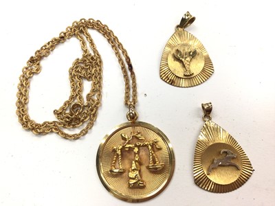 Lot 1139 - Three yellow metal zodiac sign pendants, one with a chain (all stamped 750)