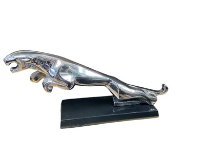 Lot 65 - Freestanding metal desk model of a leaping Jaguar, 30cm in overall length.