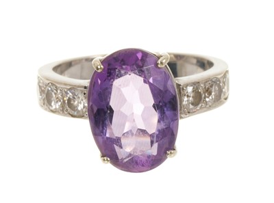 Lot 636 - Amethyst and diamond ring with an oval mixed cut amethyst flanked by six brilliant cut diamonds in white gold setting