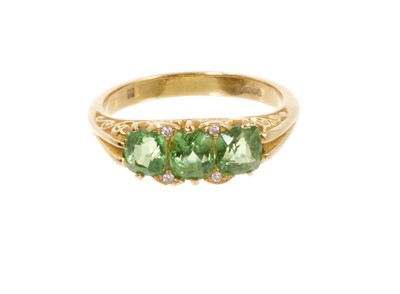 Lot 714 - Victorian style peridot and diamond ring with three oval mixed cut peridots in carved gold setting with diamond accents to the claws