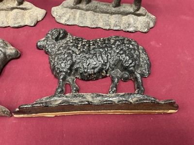 Lot 999 - Flock of four cast iron sheep doorstops, the largest 25cm long