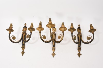 Lot 1138 - Set of three Adams revival gilt wall lights comprising the three branch and two twin branch lights, each with flaming urn cresting and harebell ornament, 35cm high