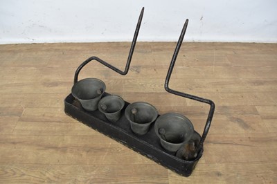 Lot 1520 - Set of four antique house team bells, with stud closed leather canopy, 56cm wide