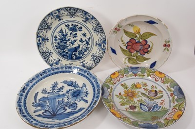 Lot 320 - Two 18th century Dutch blue and white Delft chargers, and two 19th century Delft polychrome chargers, the largest 35cm diameter