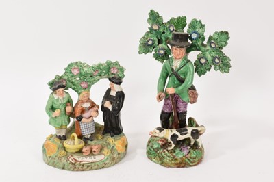 Lot 322 - Early 19th century Staffordshire pearlware figure of a huntsman with his hound, together with a reproduction of the Tithe Pig group, probably early 1900s (2)